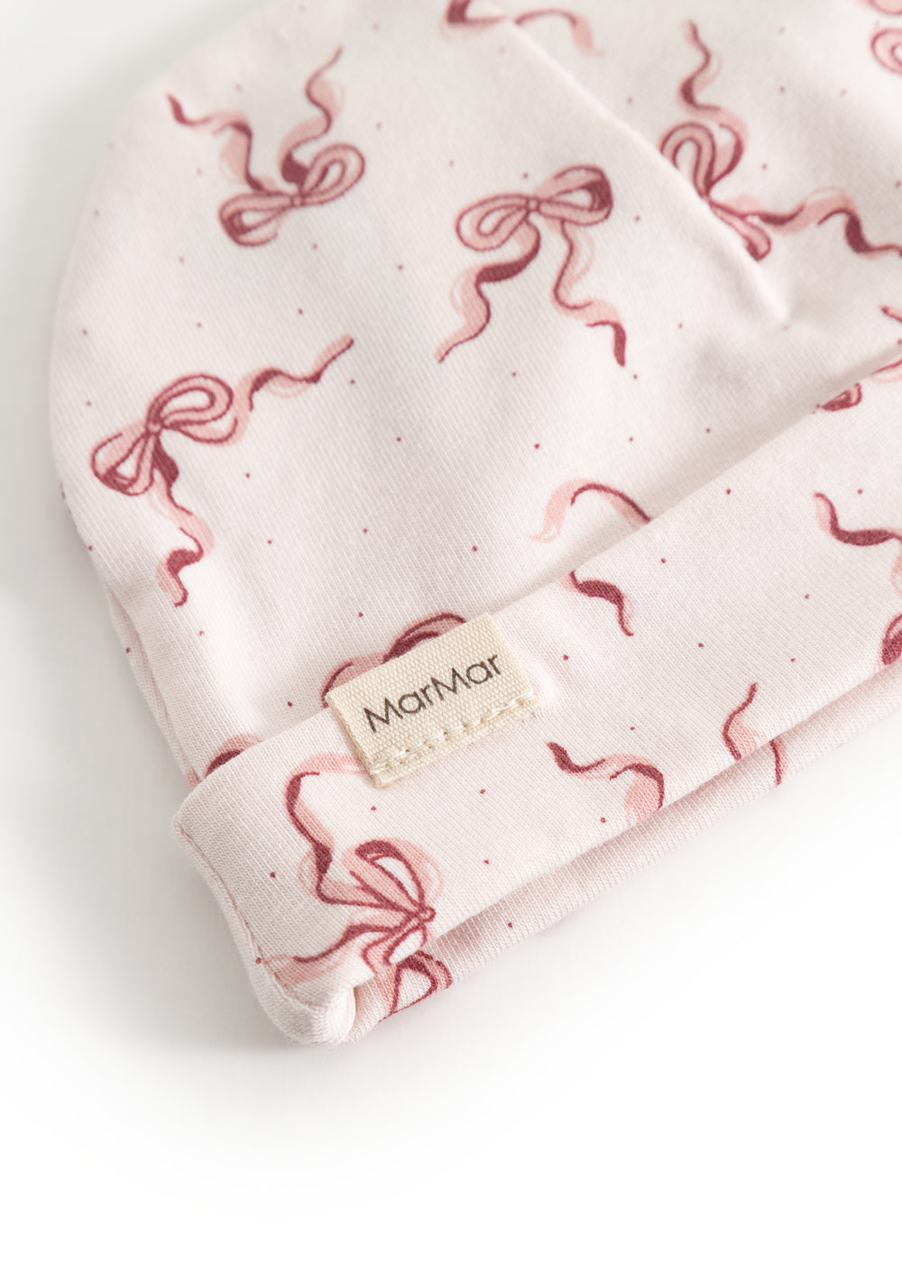 Aiko baby hat with red bows and MarMar logo on the edge