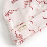 Aiko baby hat with red bows and MarMar logo on the edge