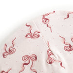 Baby bonnet in light fabric with red bows and small dots