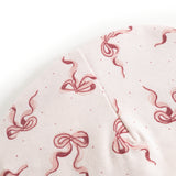 Baby bonnet in light fabric with red bows and small dots