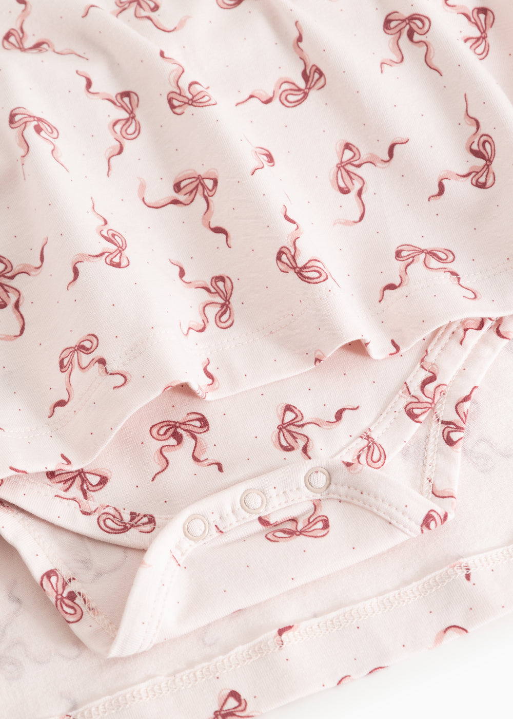 Riva dress fabric with bow print and snap buttons on placket