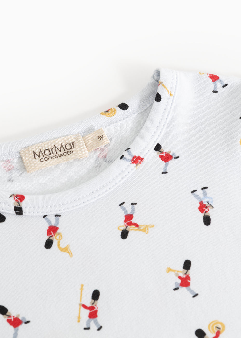 Detail of white pajamas with musician print at neckline and label tape
