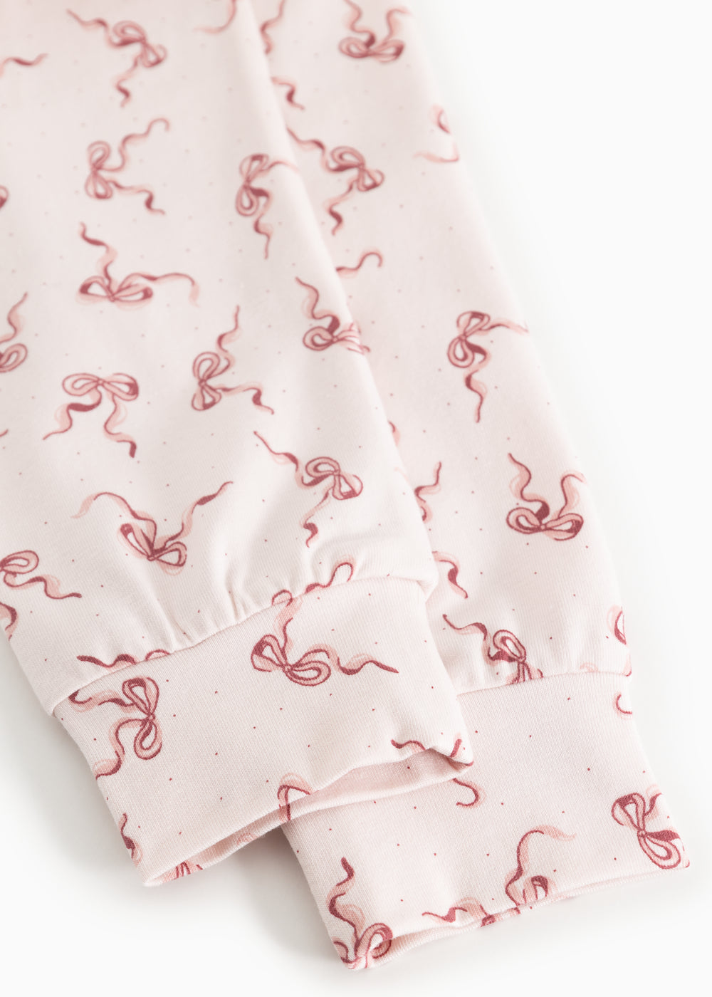 Detail of pink fabric with red bow pattern and gathered edge