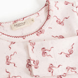 Close-up of a pink neckline with red bow print on nightwear