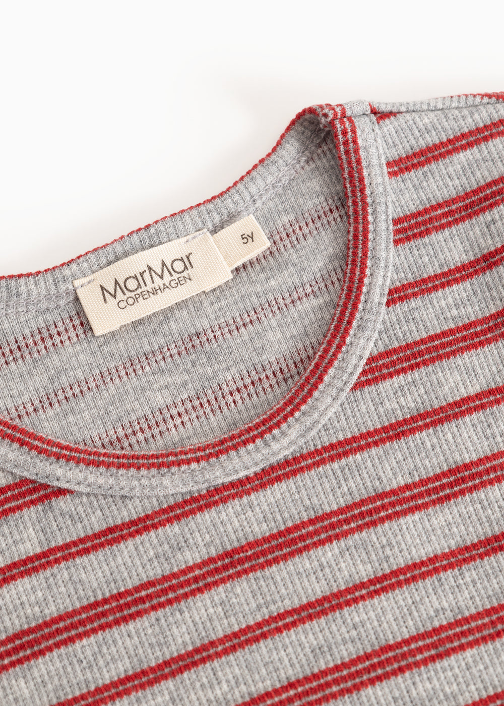 Close-up of red and white striped collar edge and label, gray background