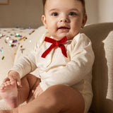 White long-sleeve baby bodysuit with red bow at the chest