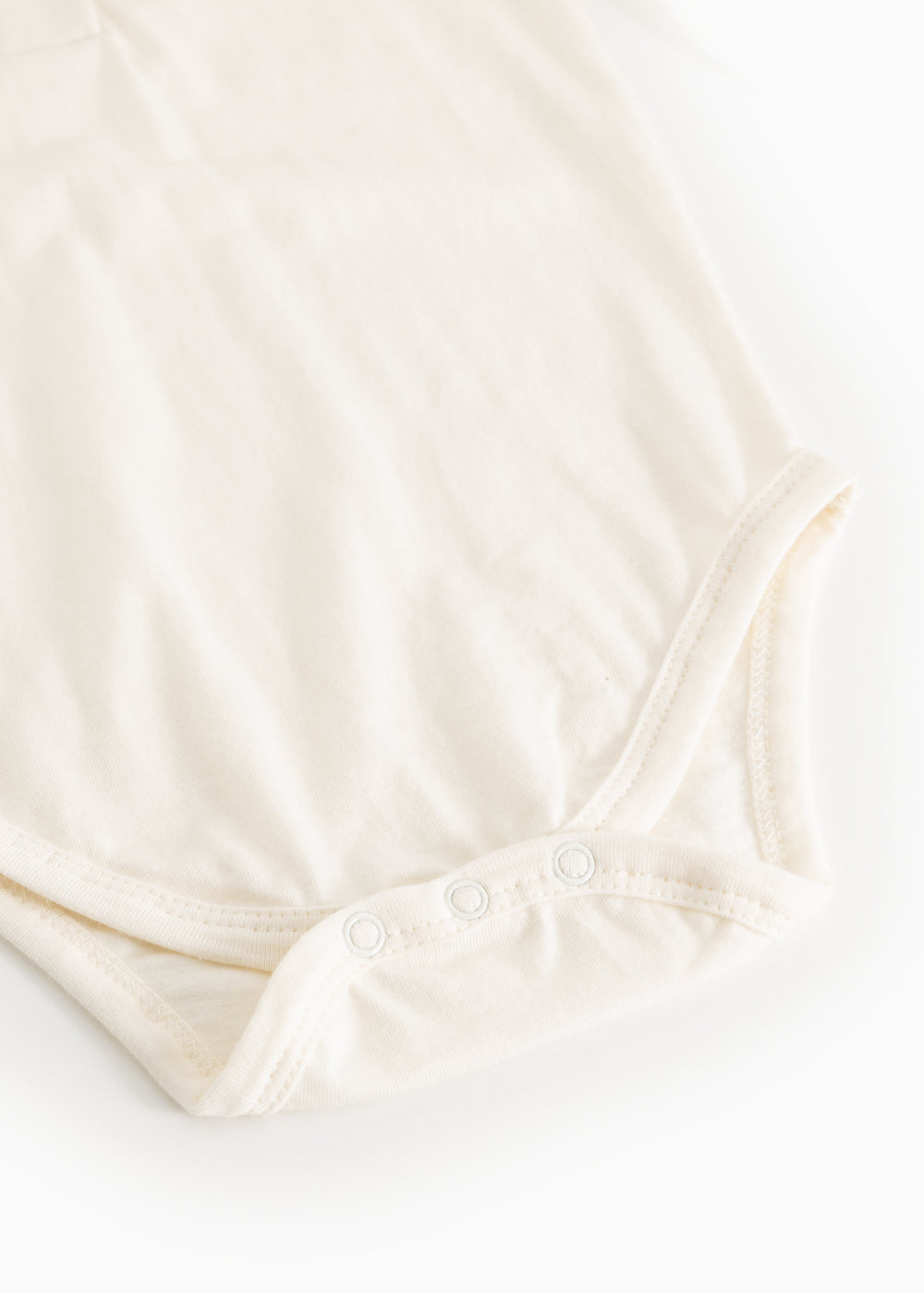 White bodystocking set viewed from below with snap buttons at the crotch