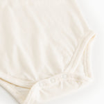 White bodystocking set viewed from below with snap buttons at the crotch