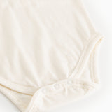 White bodystocking set viewed from below with snap buttons at the crotch