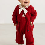 Red knitted cardigan on child with buttons at front and matching ribbed details