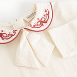 White bodystocking with red collar embroidery and bow-like detail