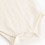 White bodystocking with red collar embroidery and snap buttons at leg opening