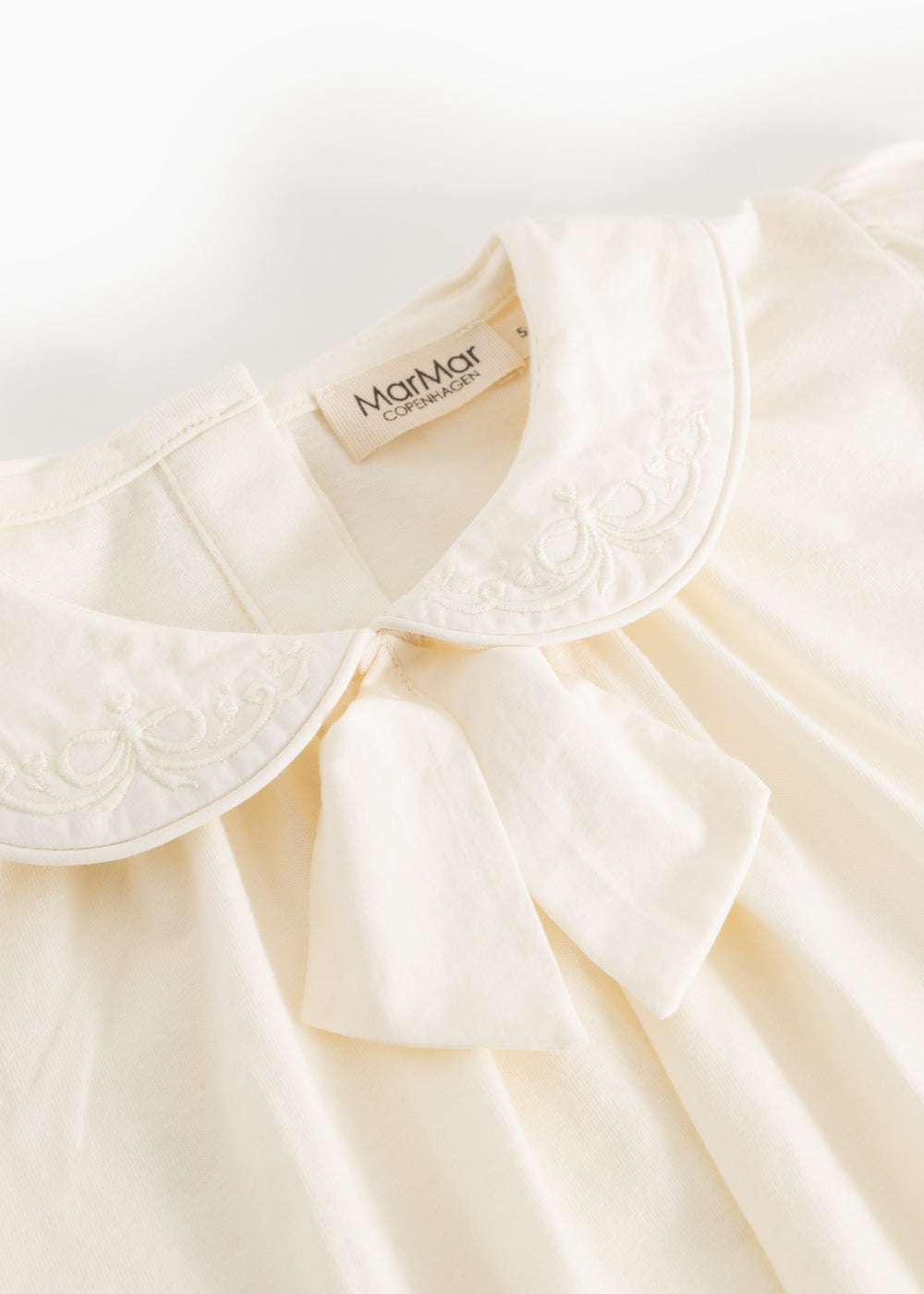 Offwhite blouse with embroidered collar edge and soft V-neckline in front