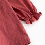 Red dress with long puff sleeves and elastic cuffs, slightly gathered hem at the bottom.