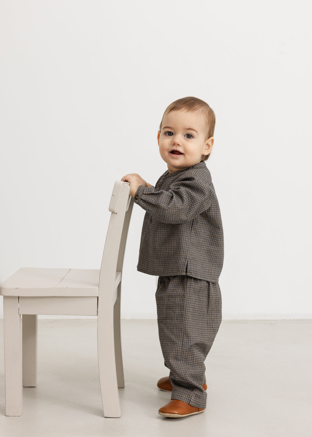 Children's houndstooth trousers with elastic waistband and straight, loose legs.