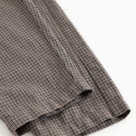 Detail of trouser leg with houndstooth pattern and small cuff at the bottom.