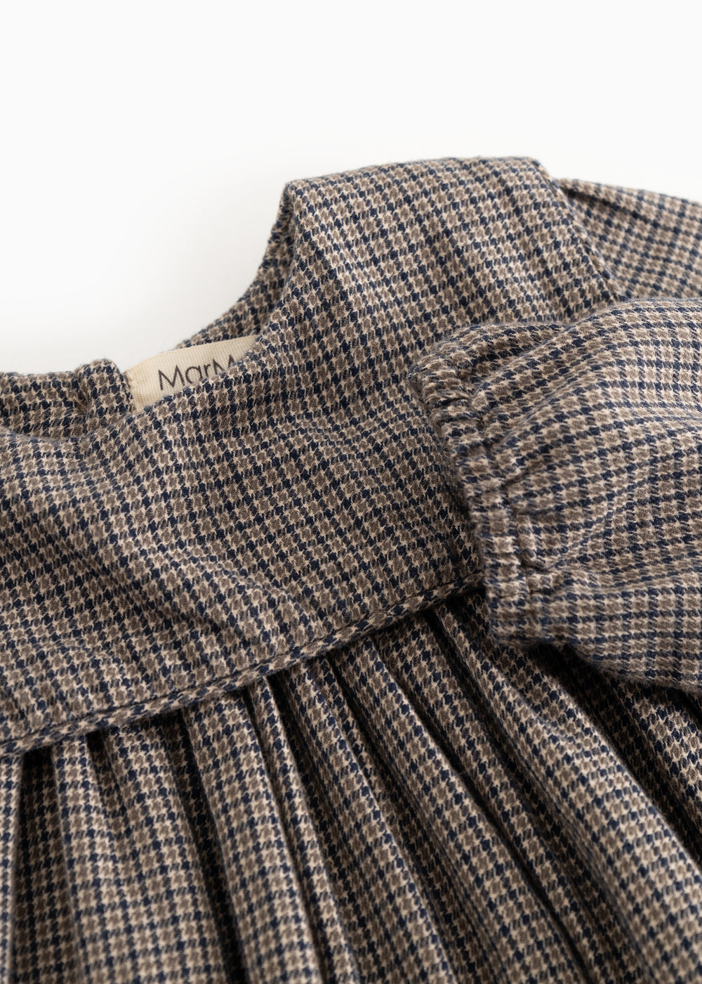 Houndstooth dress with ruffled collar and gathered chest detail, close-up