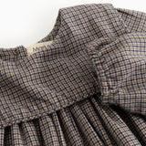 Houndstooth dress with ruffled collar and gathered chest detail, close-up