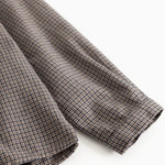 Shirt fabric in houndstooth check, folded sleeves and seam at the edge