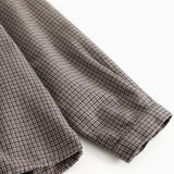 Shirt fabric in houndstooth check, folded sleeves and seam at the edge