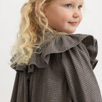 Children's dress with pied de poule pattern, round collar with ruffles, and rolled-up long sleeves.