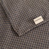 Airo scarf with houndstooth pattern and label, folded corner in brown and blue