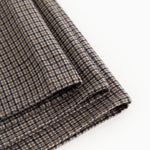 Airo scarf with houndstooth pattern, visible fringed edge and fold in brown and blue