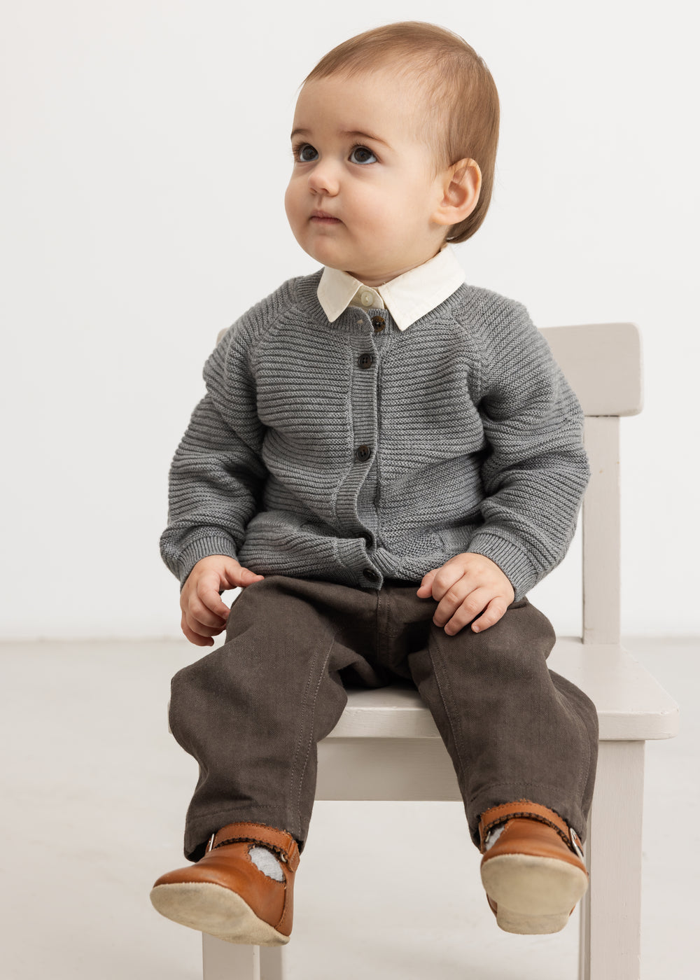 Gray knitted baby cardigan with buttons and ribbed edges
