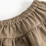 Detail: elastic waistband and gathered pleats on brown skirt