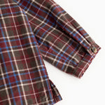 Checkered shirt sleeve with button cuff and pattern in brown, red, and blue