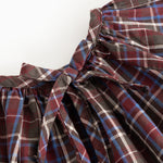 Children's blouse with check pattern and large bow detail at the neckline