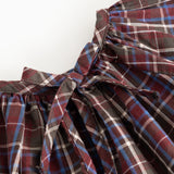 Children's blouse with check pattern and large bow detail at the neckline