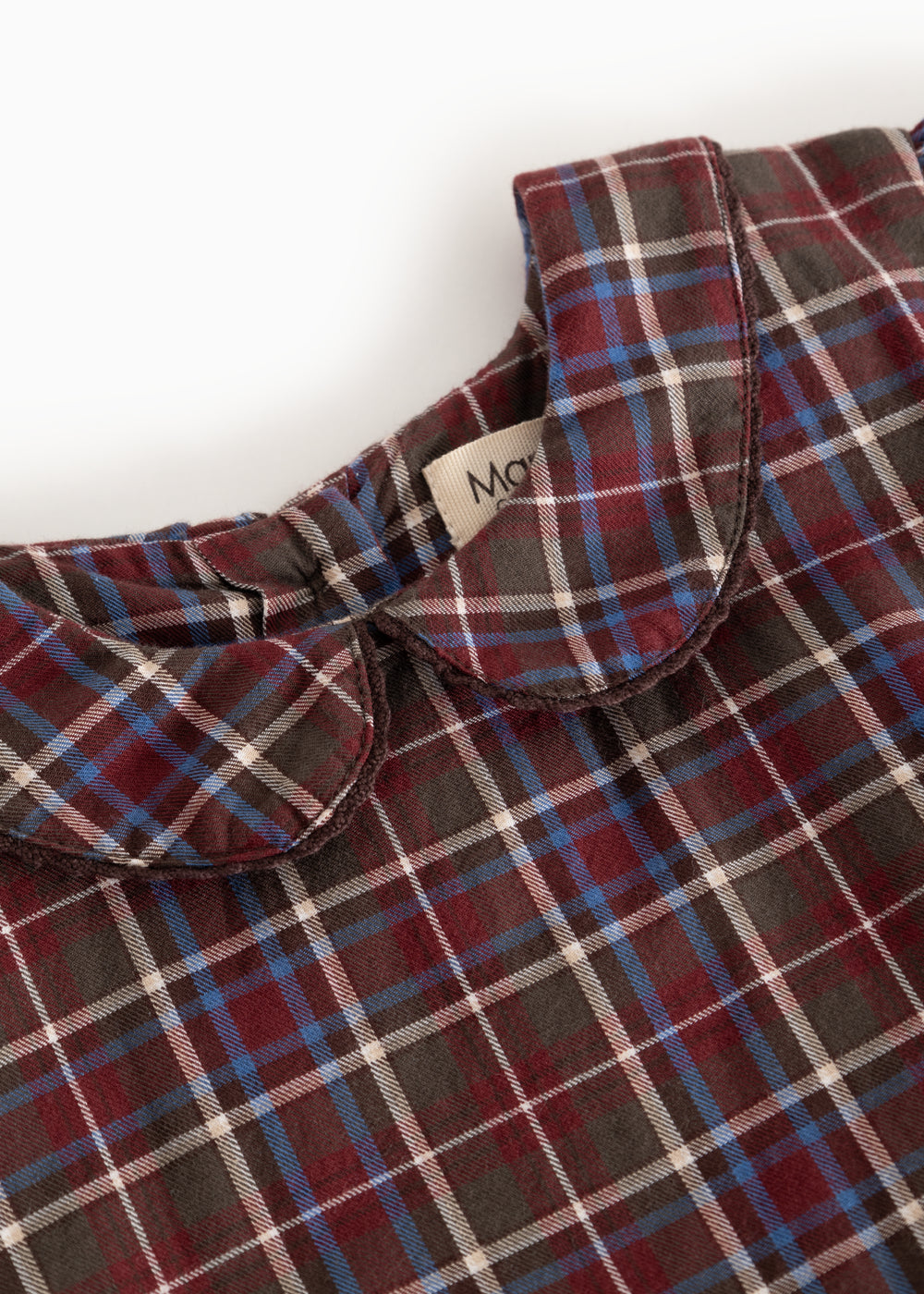 Detail of dark checkered dress with collar and button closure