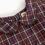 Detail of dark checkered dress with collar and button closure