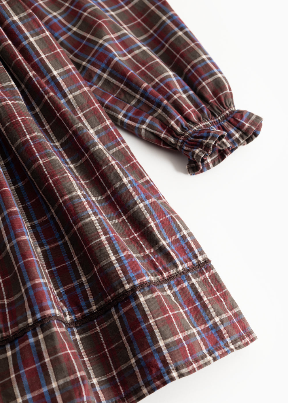 Dark checkered dress with long sleeves and gathered cuffs and hem