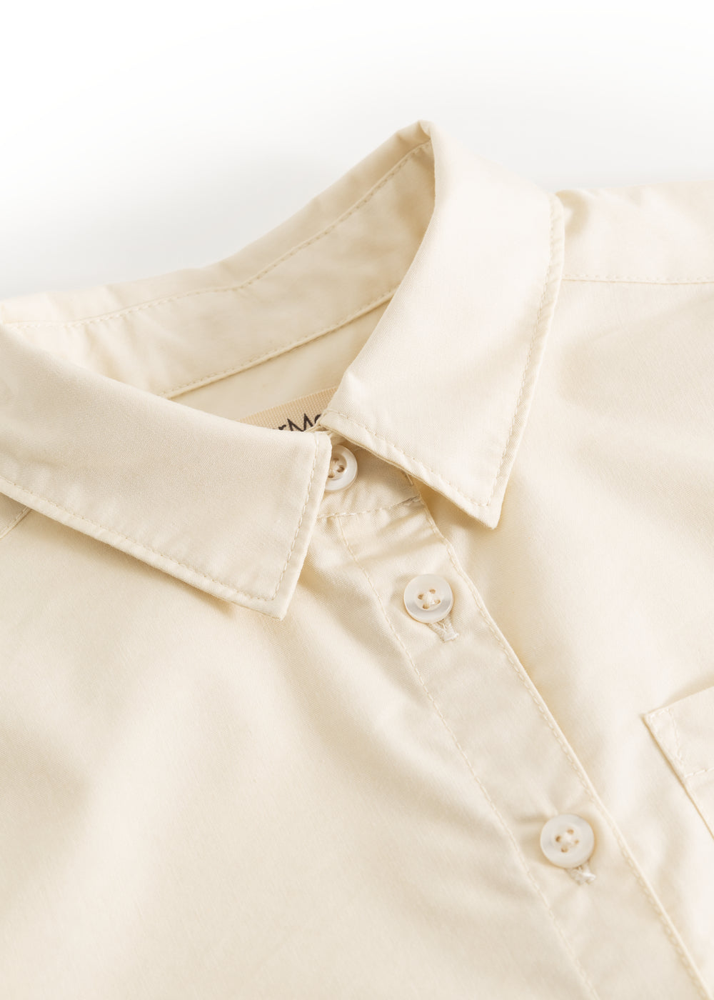 Light cream shirt collar with button placket and visible buttons