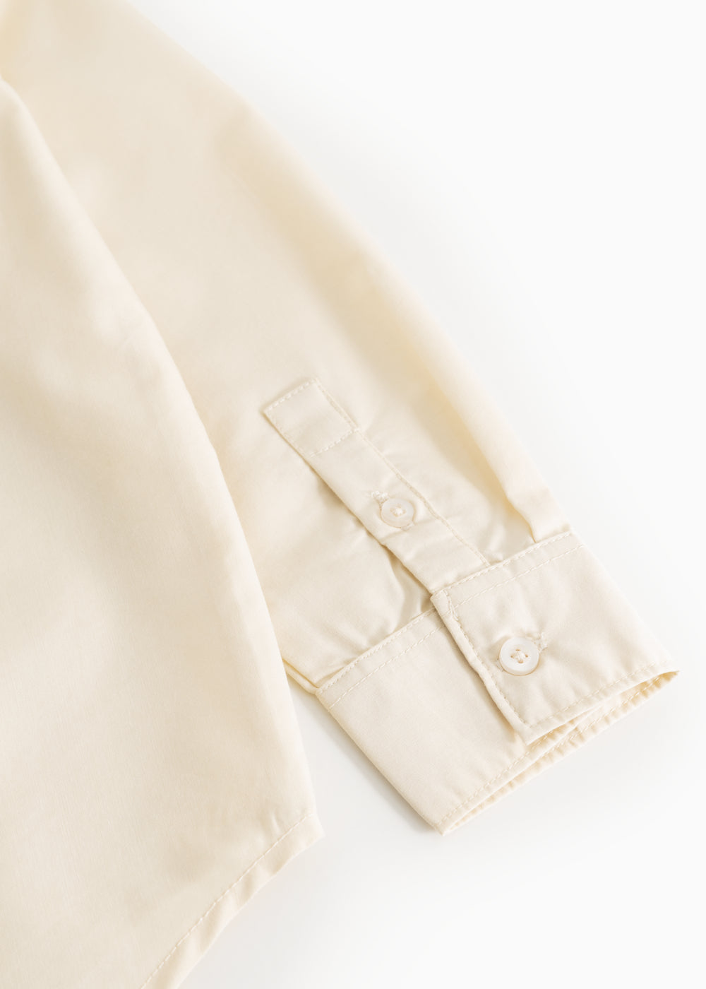 Light cream cuff with button and seam details at sleeve end