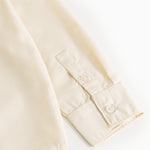 Light cream cuff with button and seam details at sleeve end