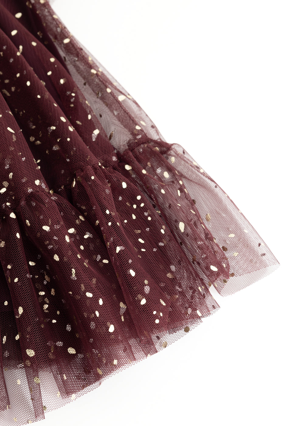 Detail of dark purple tulle skirt with gold dots and layered transparent edge