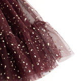 Detail of dark purple tulle skirt with gold dots and layered transparent edge