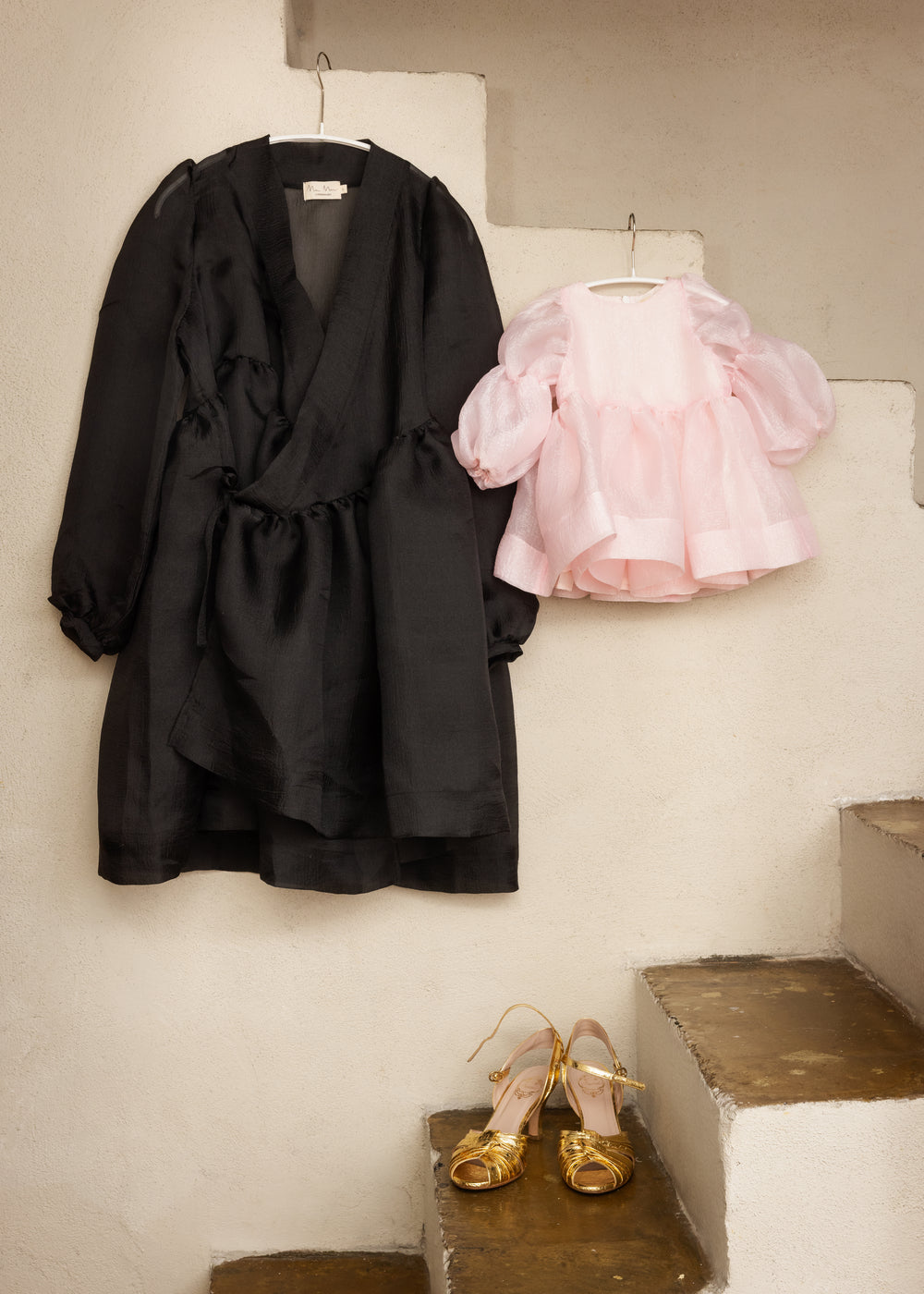 Pink baby dress on hanger with puff sleeves and ruched top