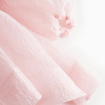 Pink tulle dress with puff sleeves and gathered detail at the cuff