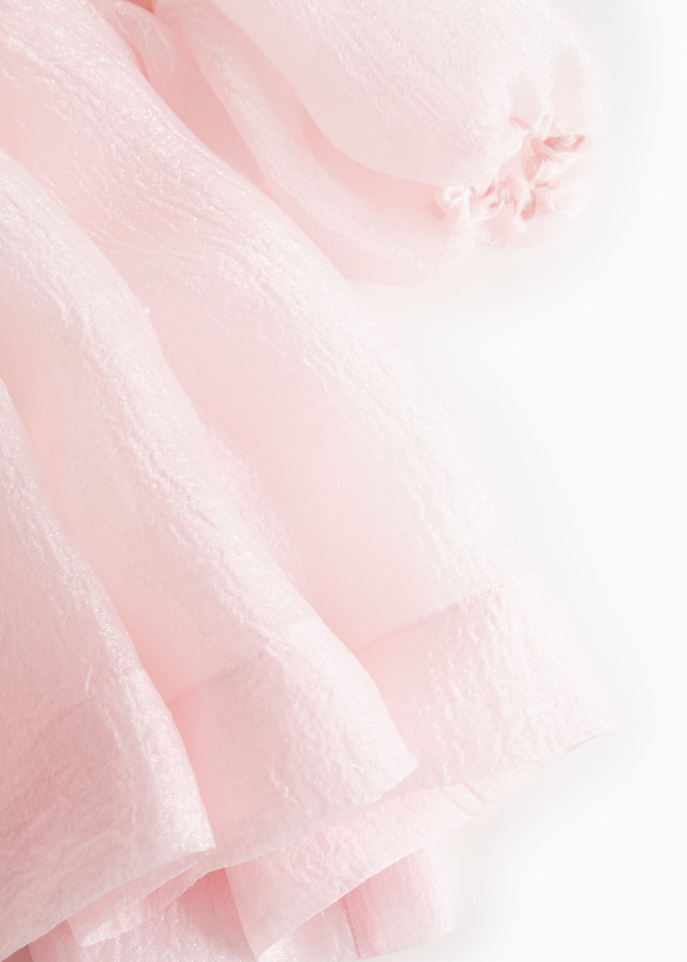 Pink tulle sleeve with delicate ruffle edge and layered finish at cuff