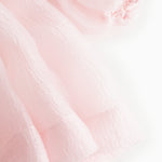 Pink tulle sleeve with delicate ruffle edge and layered finish at cuff