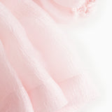 Pink tulle sleeve with delicate ruffle edge and layered finish at cuff