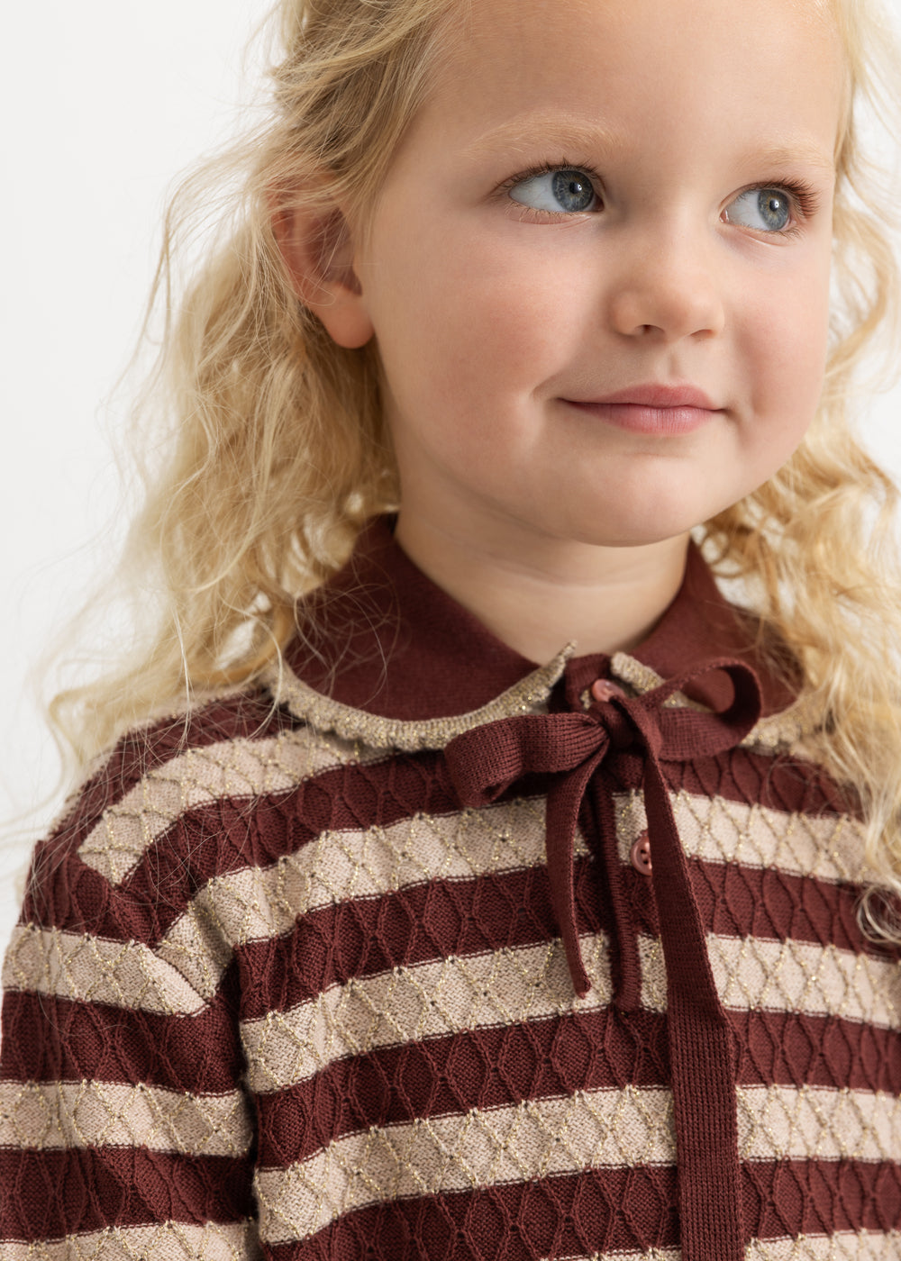 Knitted sweater with brown-red and cream stripes and a bow at the neckline