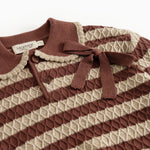 Knitted sweater with reddish-brown and cream stripes, buttons and bow at the neck
