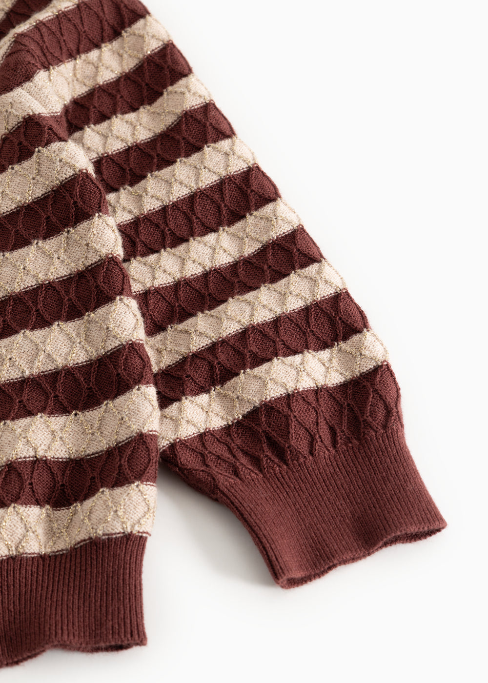 Knitted sweater with brown-red and cream stripes and ribbed cuffs at the sleeves