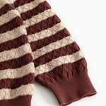 Knitted sweater with brown-red and cream stripes and ribbed cuffs at the sleeves