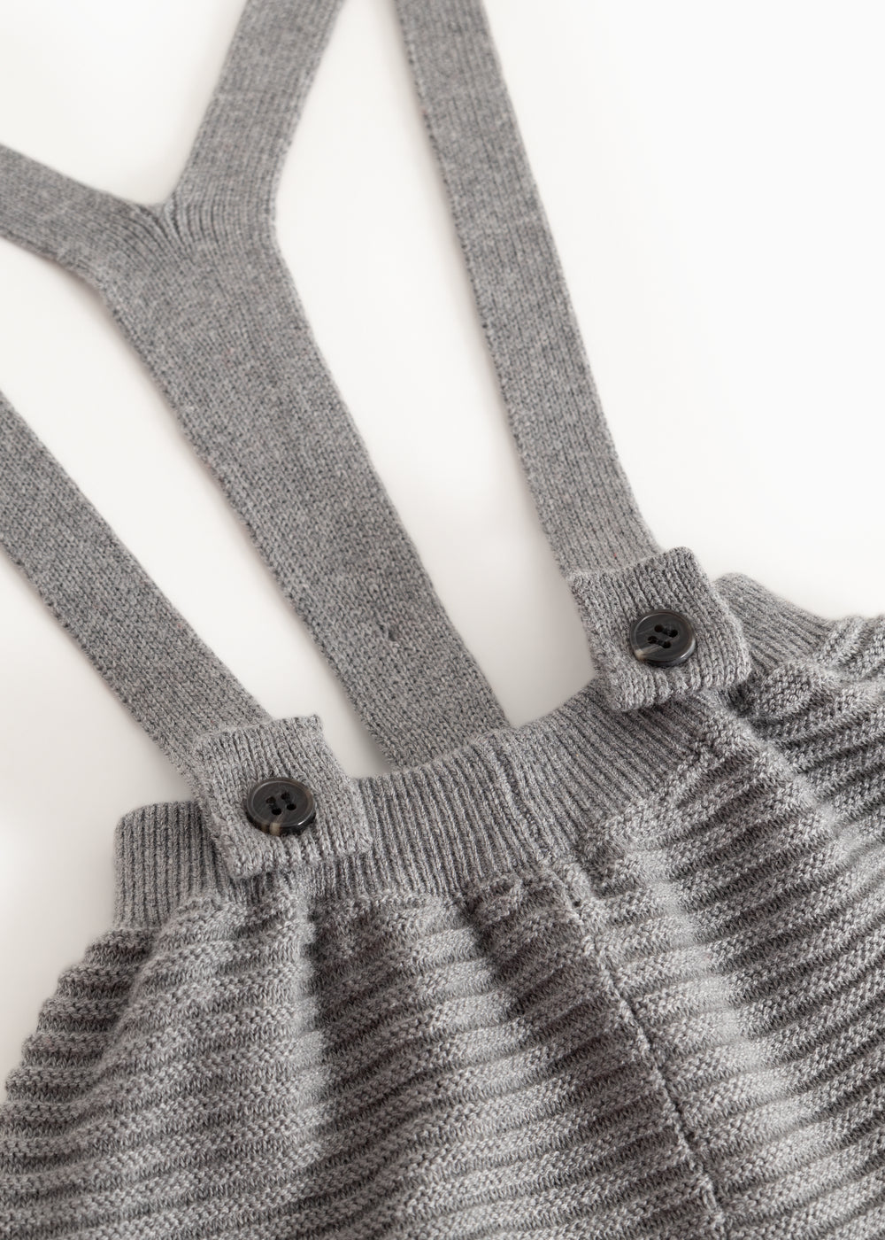 Gray suspenders with buttons and gathered chest piece on knitted pants
